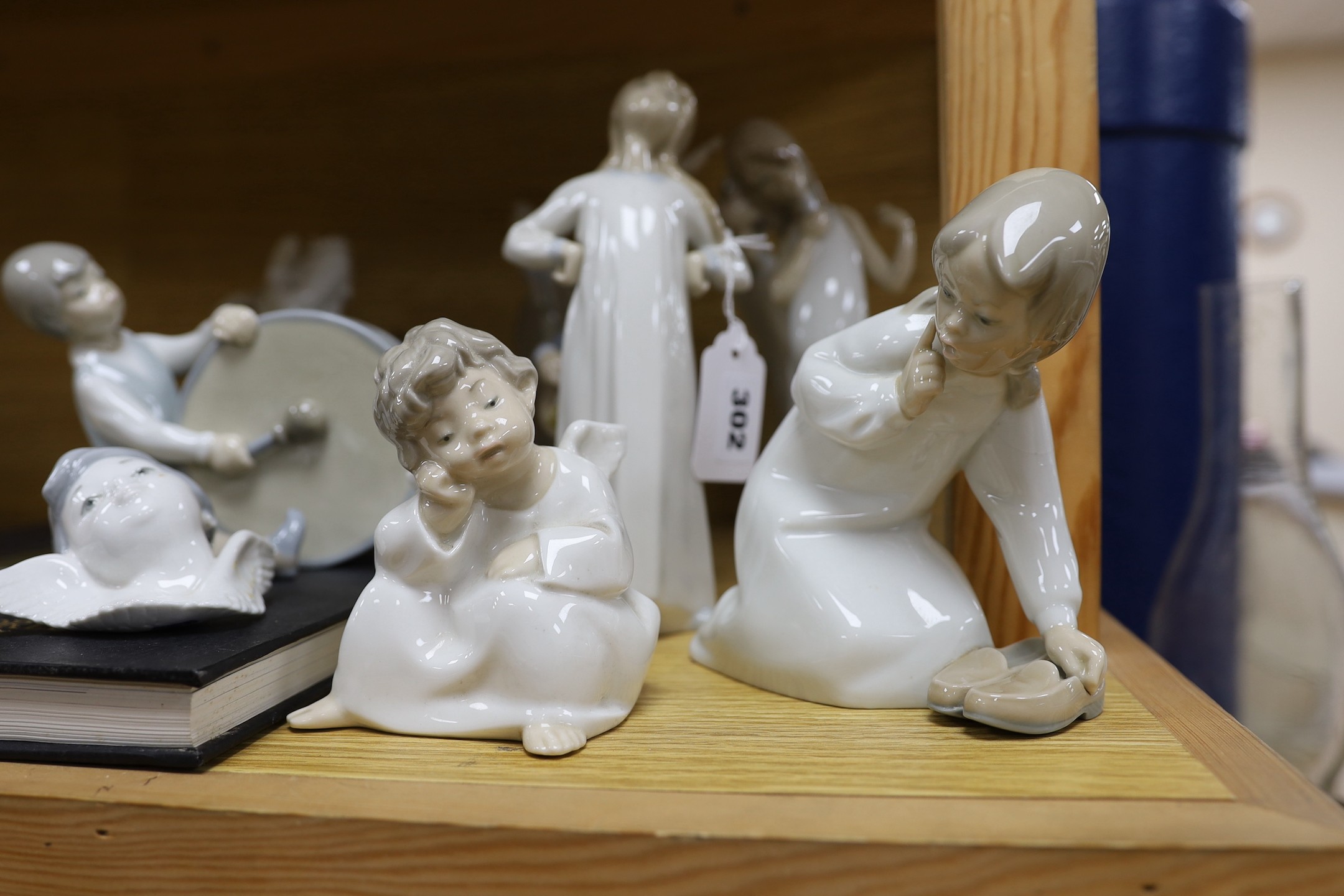 A Lladro collection: seven figures, five further damaged figures and a Lladro reference book